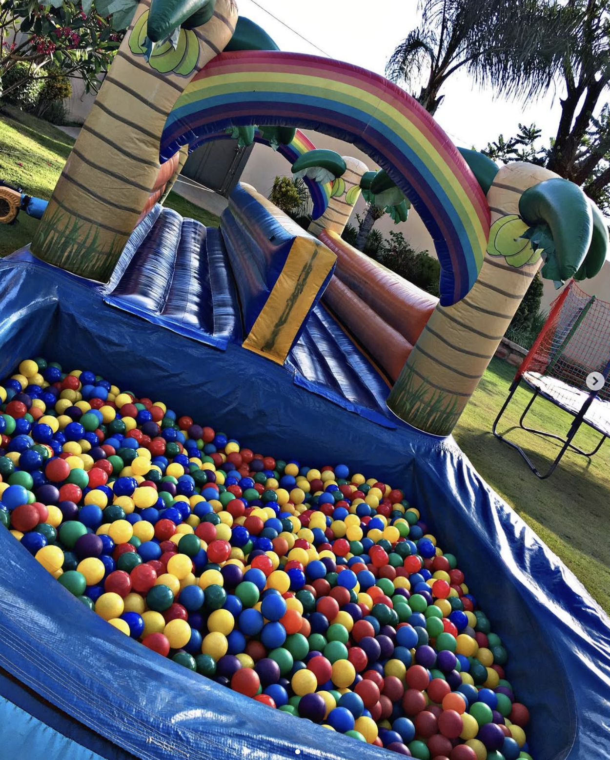 Piscina de bolinhas coloridas dentro de um inflável com arco-íris